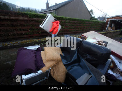 John Morrison enlève ses effets personnels en attendant qu'ils soient ramassés de sa maison après avoir été endommagés par les inondations la semaine dernière alors que le dérangement se poursuit à Ballater. Banque D'Images