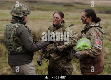 Le ministre des Forces armées Penny Mordount (à gauche) discute avec le sergent d'état-major Bernadette Johnson du 47 Regiment, l'Artillerie royale et le sergent Sally Stuart de la Gendarmerie royale du Canada (à droite) après un exercice de tir en direct par des membres de l'École de combat d'infanterie de l'aire d'entraînement de Sennybridge dans les Brecon Beacons, au pays de Galles. Banque D'Images