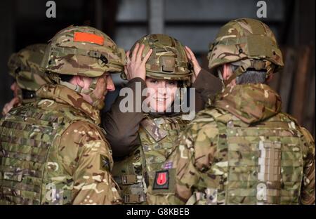 La ministre des Forces armées Penny Mordtante ajuste son casque avant de regarder un exercice de tir en direct par des membres de l'école de combat d'infanterie à l'aire d'entraînement de Sennybridge, dans les Brecon Beacons, au pays de Galles. Banque D'Images