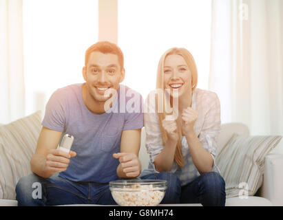 Smiling couple avec popcorn sports team cheering Banque D'Images