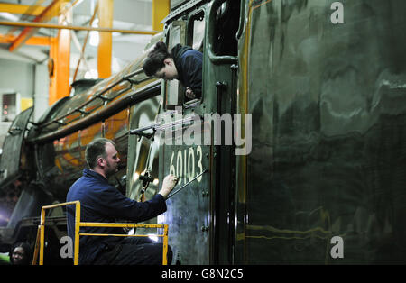 Mike O'Connor, peintre du patrimoine, peint dans le numéro du moteur sur la nouvelle décoration verte du Flying Scotsman observé par sa fille, Teriann, 21 ans, L'OMS travaille également sur la locomotive en tant que peintre du patrimoine, avant son retour officiel à la vapeur la semaine prochaine, dans un atelier au Musée national des chemins de fer à York. Banque D'Images