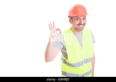 Les jeunes joyeux builder portant un gilet et casque montrant ok signe en tant que concept bon travail isolé sur blanc avec copyspace Banque D'Images