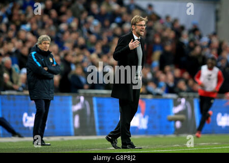 Jurgen Klopp, directeur de Liverpool, a donné des instructions à son équipe en tant que directeur de Manchester City Manuel Pellegrini (à gauche), regarde derrière lui lors de la finale de la coupe Capital One au stade Wembley, à Londres. Banque D'Images