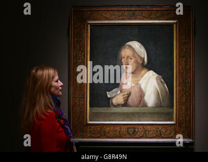 Un membre du personnel regardant la Vecchia de Giorgione qui est exposé dans le cadre de l'exposition dans l'âge de Giorgione, à l'Académie royale des Arts, Londres. Banque D'Images