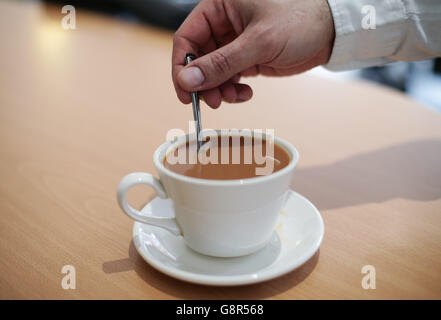 Une tasse de thé est remuée dans un café de Londres. Banque D'Images