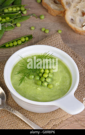 Une assiette de soupe purée de pois verts à l'aneth sur une table Banque D'Images