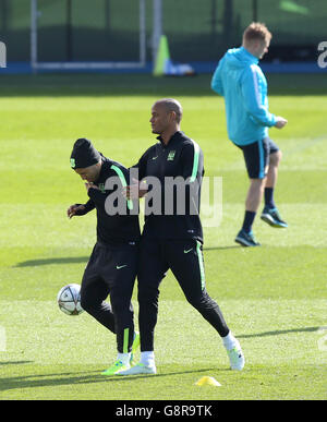 Sergio Aguero (à gauche) de Manchester City réagit après avoir été pris dans le visage avec un ballon de football par le coéquipier Vincent Kompany lors d'une session d'entraînement à la City football Academy, Manchester. Banque D'Images