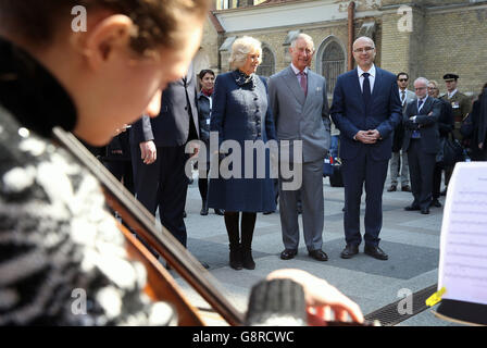 Le prince de Galles et la duchesse de Cornouailles écoutent un orchestre de chambre qui se produit sur une place de marché à Novi Sad, en Serbie, le quatrième jour de leur tournée de six jours dans les Balkans. Banque D'Images