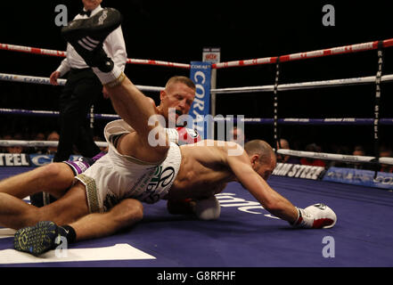 Terry Flanagan (à gauche) et Derry Mathews tombent au sol pendant le championnat du monde léger WBO à l'arène Liverpool Echo. Banque D'Images