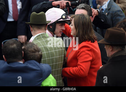 Le Jockey Ruby Walsh (au centre) embrasse la propriétaire Susannah Ricci (à droite) et son mari Rich Ricci (à gauche) alors qu'ils célèbrent la victoire du trophée défi de haies Stan James Champion avec Annie Power lors de la journée Champion du Festival Cheltenham 2016 à Cheltenham Racecourse. Banque D'Images