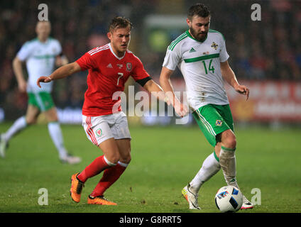 Stuart Dallas (à gauche), en Irlande du Nord, et George Williams, au pays de Galles, se battent pour le bal lors de l'International friendly au Cardiff City Stadium, à Cardiff. Banque D'Images