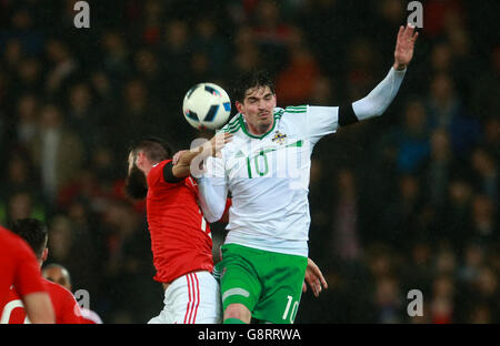 En Irlande du Nord, Kyle Lafferty (à droite) saute le plus haut pour gagner le ballon lors de l'International friendly au Cardiff City Stadium, Cardiff. Banque D'Images