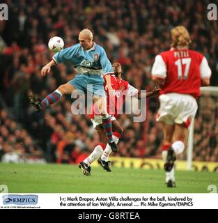 Mark Draper de Aston Villa (à gauche) saute devant Ian Wright d'Arsenal (au centre) pour gagner le ballon Banque D'Images