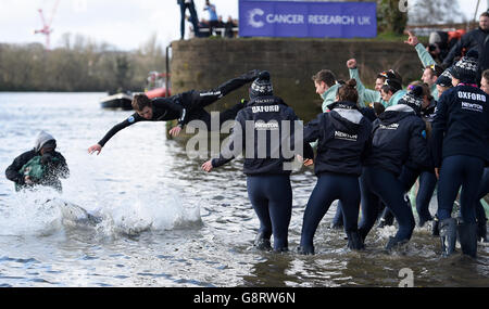 Cambridge Men's Blue Boat cox Ian Middleton (deuxième à gauche) et Oxford Women's Blue Boat cox Rosemary Ostfeld (à gauche) sont jetés dans la Tamise tandis que les deux équipes célèbrent leurs victoires dans les courses de bateaux respectives sur la Tamise, Londres. Banque D'Images