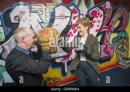 La première ministre Nicola Sturgeon essaie une paire de gants de boxe alors qu'elle rencontre l'entraîneur sportif Martin O'Brien lors d'une visite de campagne électorale au projet de développement communautaire de Glencassles à Wishaw, dans le Lanarkshire du Nord. Banque D'Images