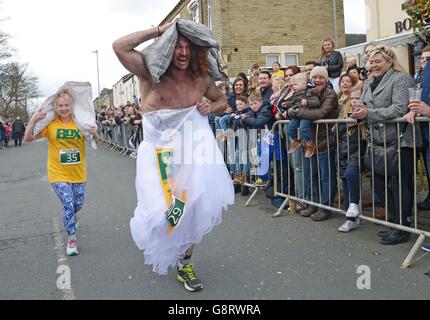 Joel Hicks termine le cours en portant une robe de mariage lors des championnats du monde de transport du charbon à Gawthorpe, dans le West Yorkshire. Banque D'Images