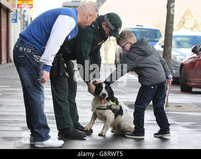 Un jeune garçon accueille un membre de l'unité PSNI K-9 en tant que membres de l'ordre loyal protestant les apprentis garçons de Derry défilent à travers Lurgan en Irlande du Nord. Banque D'Images