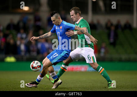 Glenn Whelan, de la République d'Irlande, et Marek Hamsik (à gauche), de Slovaquie, se battent pour le bal lors d'un match international amical au stade Aviva, à Dublin. Banque D'Images