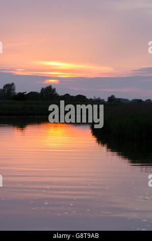 Coucher du soleil sur la rivière Bure de Stracey Arms près de Acle. Norfolk Broads. UK. De juin. Banque D'Images