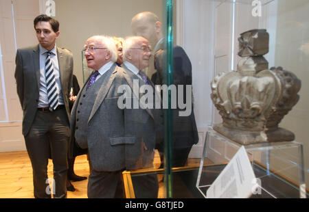 Le président Michael D Higgins (au centre) avec Simon Harris TD, le ministre d'État aux ministères des Finances (à gauche) qui passe devant la Couronne des armoiries royales du palais de justice à l'ouverture du nouveau centre d'accueil à la prison de Kilmainham, à Dublin. Banque D'Images