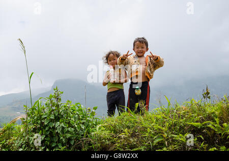 Deux jeunes enfants vietnamiens au Vietnam du Nord campagne dire bonjour et faire le signe v part en face de l'appareil photo Banque D'Images