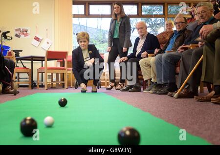 Nicola Sturgeon, chef du SNP (à gauche), joue des bols de tapis avec les résidents du projet Arden House à Leven lors d'une visite de campagne à Fife, Où elle a souligné le projet de SNP de construire cinq nouveaux centres de traitement où des interventions chirurgicales planifiées auraient lieu - un mouvement qui, selon elle, aidera le service de santé à faire face au vieillissement de la population écossaise. Banque D'Images