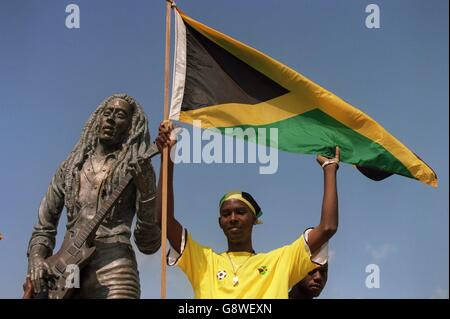 Football - qualificatif de coupe du monde - Jamaïque / Mexique.Un fan de la Jamaïque se tient devant une statue de Bob Marley Banque D'Images