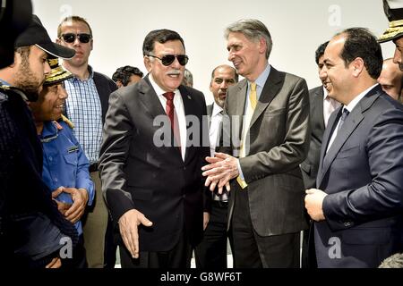 Le secrétaire aux Affaires étrangères Philip Hammond, au centre-droit, visite une base navale avec le premier ministre désigné de Libye, Fayez Sarraj, au centre-gauche, lors de sa visite à Tripoli, en Libye. Banque D'Images