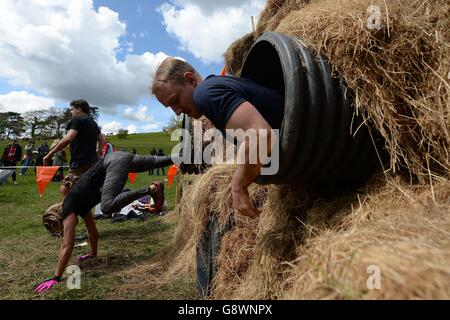 Les participants sortent des tunnels lors de l'événement « King of the Sables » Tough Mudder London West au Culden Faw Estate près de Henley-on-Thames. Banque D'Images