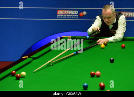 John Higgins à la table dans son match contre Alan McManus pendant le onze jour des Championnats du monde de Betfred Snooker au Crucible Theatre, Sheffield. Banque D'Images