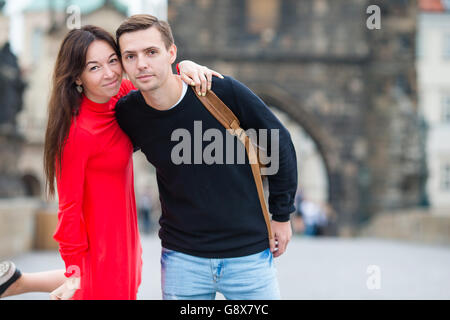 Heureux couple en train de marcher sur le pont Charles à Prague. Les amateurs de paysage urbain avec sourire profiter de monuments célèbres. Banque D'Images