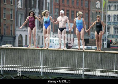 Les nageurs sautent du pont du millénaire jusqu'à la rivière Liffey à Dublin, devant la 85e nage Liffey, qui permettra à des centaines de concurrents de nager dans les 2.4 kilomètres de Watling Street Bridge à la maison personnalisée. Banque D'Images