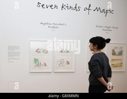 Un conservateur de galerie applique les touches finales aux illustrations exposées dans l'exposition de sept genres de magie, la première exposition qui aura lieu à la nouvelle Galerie Quentin Blake à la Maison de l'Illustration de King's Cross, Londres. Banque D'Images