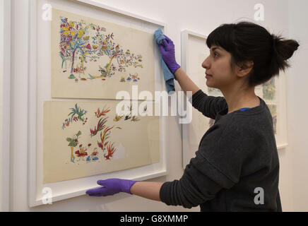 Un conservateur de galerie applique les touches finales aux illustrations exposées dans l'exposition de sept genres de magie, la première exposition qui aura lieu à la nouvelle Galerie Quentin Blake à la Maison de l'Illustration de King's Cross, Londres. Banque D'Images