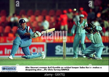 Cricket - Sharjah Champions Trophée - Angleterre / Inde.Alec Stewart (à gauche), en Angleterre, balaie Anil Kumble en Inde alors que le gardien de rue Saba Karim (à droite) fait une plongée débiliquée Banque D'Images