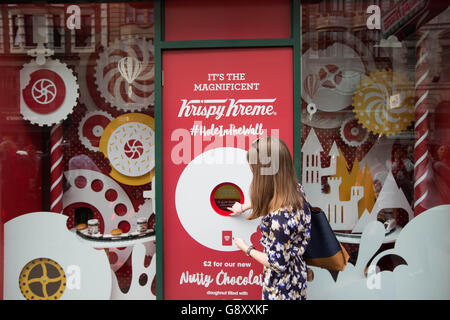 Les clients font la queue pour la nouvelle édition limitée Krispy Kreme 'Nutty Chocolatta' donut au lancement pop-up Hole in the Wall, à Holborn, Londres. Banque D'Images