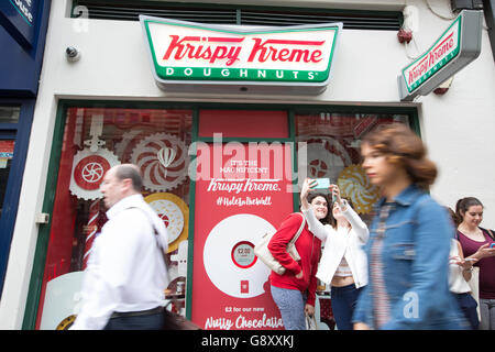 Les clients font la queue pour la nouvelle édition limitée Krispy Kreme 'Nutty Chocolatta' donut au lancement pop-up Hole in the Wall, à Holborn, Londres. Banque D'Images