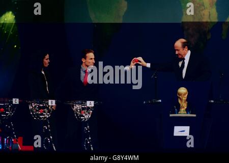 le secrétaire général de la FIFA, Sepp Blatter (à droite) reçoit une balle de Jean-Pierre Papin (au centre) regardé par l'internationale féminine américaine Julie Foudy (gauche) Banque D'Images