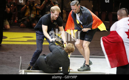 Le prince Harry aide Anna Hall Mayzik après qu'elle est tombée alors qu'il présentait une médaille d'argent à un athlète allemand aux Invictus Games 2016 à ESPN Wide World of Sports à Orlando, en Floride. Banque D'Images