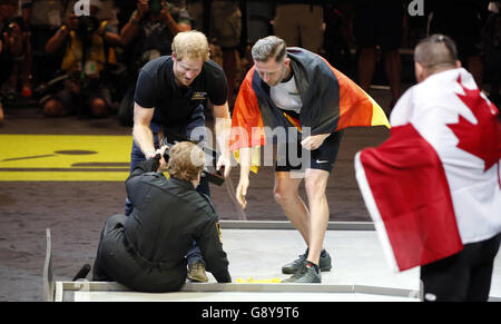 Le prince Harry aide Anna Hall Mayzik après qu'elle est tombée alors qu'il présentait une médaille d'argent à un athlète allemand aux Invictus Games 2016 à ESPN Wide World of Sports à Orlando, en Floride. Banque D'Images