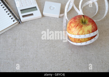 Apple, ruban à mesurer, bloc-notes et calculatrice pour l'arrière-plan de régime, régime weightloss Banque D'Images