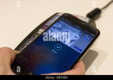 Kingston, Ontario, Canada. 16 mai, 2016. Un client utilise payer Apple app sur un iPhone à payer un article à aller dans un magasin d'informatique, Kingston (ON), le 16 mai 2016. © Lars Hagberg/ZUMA/Alamy Fil Live News Banque D'Images