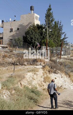 Bethléem, Cisjordanie, territoire palestinien. 1er juillet 2016. Un photographe palestinien réagit comme la police des frontières israélienne feu gaz lacrymogènes près d'une porte de barbelés de la partie israélienne controversée barrière de séparation entre la ville cisjordanienne de Bethléem et Jérusalem, après une tentative par les hommes palestiniens de passer en douce et se rendre dans la mosquée Al-Aqsa à Jérusalem à travers elle composé, à la suite d'une commande par la police israélienne a deux jours plus tôt pour empêcher les Palestiniens de traverser à prier sur le quatrième et dernier vendredi du mois du Ramadan en raison d'une hausse de la violence à l'emplacement, le 1 juillet Banque D'Images