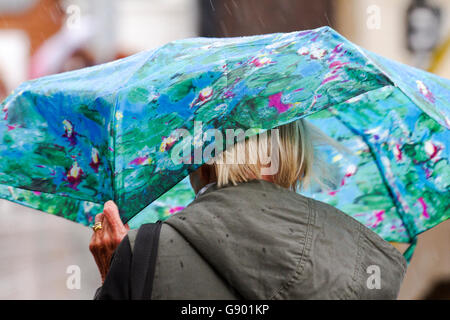 Manchester, UK. 1er juillet 2016. Météo France : de fortes averses de pluie torrentielles shoppers tremper dans le centre-ville de Manchester. Le temps incertain dans le nord-ouest de l'Angleterre, pris par surprise les acheteurs avec de lourdes explosions de pluie cet après-midi. Certains ont été préparés, mais d'autres utilisent des techniques alternatives à l'abri. Credit : Cernan Elias/Alamy Live News Banque D'Images