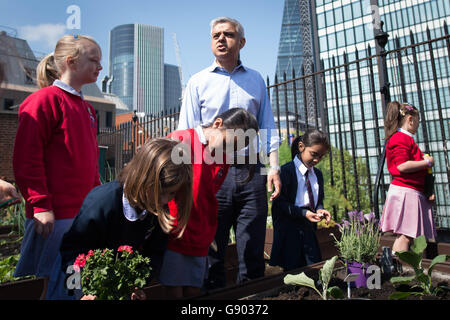 Le maire de Londres nouvellement élu, Sadiq Khan, rencontre des élèves à l'école primaire de la Fondation Sir John Cass de la ville de Londres, où il a aidé les enfants à planter des semences et des fleurs sur leur jardin de toit vert après avoir vu une station de surveillance de la pollution de l'air dans le terrain de jeu. Banque D'Images