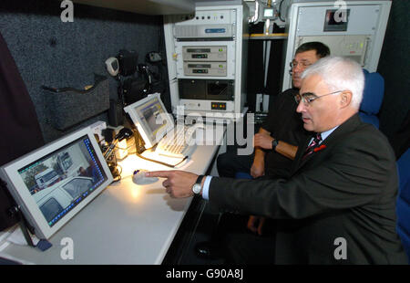 Le secrétaire aux Transports Alistair Darling (premier plan) voit une fourgonnette de surveillance par l'opérateur de reconnaissance automatique de plaques d'immatriculation DickTranter lors d'une répression contre les conducteurs non assurés à Birmingham, le mardi 8 novembre 2005. Les mesures sévères visant à sévir contre les conducteurs non assurés ont été dévoilées aujourd'hui par le secrétaire aux Transports Alistair Darling. À partir d'aujourd'hui, les forces de police à travers le pays peuvent utiliser des caméras de reconnaissance automatique de plaque d'immatriculation pour repérer et finalement saisir et détruire les voitures roulant sans assurance. Les caméras sont liées à une base de données qui contient les détails de tous les véhicules immatriculés au Royaume-Uni Banque D'Images