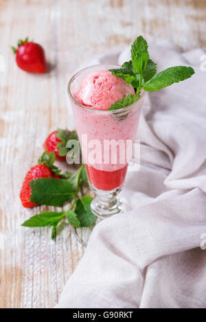 Verre de fraise dessert avec un sorbet et menthe, servi avec les baies fraîches sur fond texturé en bois blanc avec du r Banque D'Images