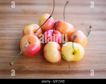 Belle, douce, et de délicieuses cerises Rainier sur une planche à découper en bambou. Banque D'Images