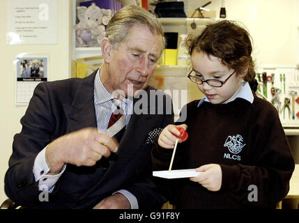 Prince of Wales aide Georgie Strauss, 7 ans, avec son travail du bois lors d'une visite à la North London Collegiate School,Lundi 21 novembre 2005 après avoir rencontré précédemment des volontaires qui aident à reconstruire des parties du Sri Lanka touchées par le tsunami du lendemain de Noël en exploitant le méthane du bison.Charles a visité le Département de l'éducation et des compétences dans le centre de Londres,où il a rencontré trois femmes qui ont contribué à la mise en place d'un « centre écologique » dans l'une des régions les plus touchées.Mais ils n'ont pas réussi à parler au Prince de l'un de leurs projets les plus innovants - la collecte de « bio-gaz » des fèces de buffle pour alimenter à proximité Banque D'Images