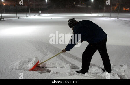 L'hôtel Nightporter Gregory G balaie la neige du parking du complexe Aviemore, début vendredi 25 novembre 2005, alors que la neige tombait la nuit. Certaines parties de l'Écosse, de l'Angleterre et du pays de Galles se sont vantées aujourd'hui d'avoir encore plus de perturbations à mesure que les averses d'hiver se poursuivaient. Les routes ont été fermées et des écoliers ont été envoyés à la maison dans le nord de l'Écosse hier après la première forte chute de neige de l'hiver. Voir PA Story MÉTÉO neige. APPUYEZ SUR ASSOCIATION photo. Le crédit photo devrait se lire comme suit : Andrew Milligan/PA Banque D'Images